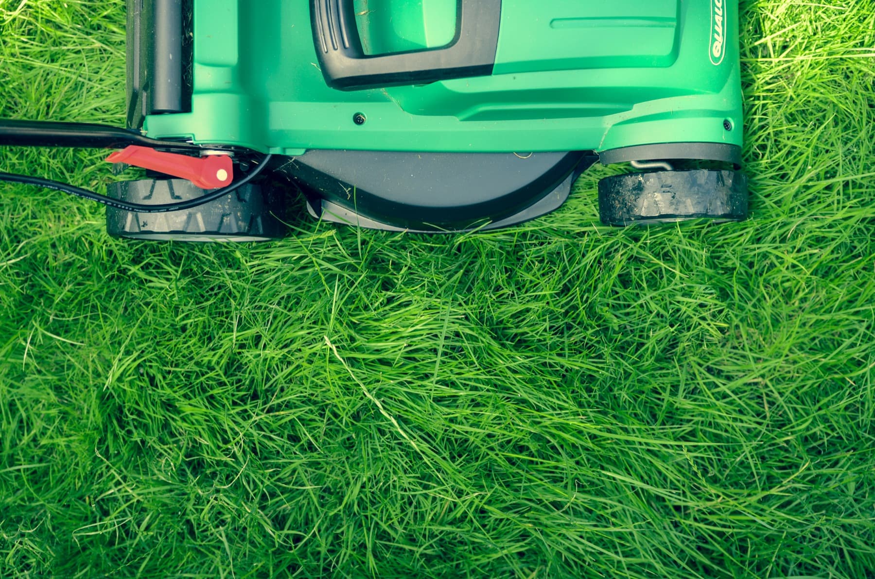 A lawn mower on green grass.